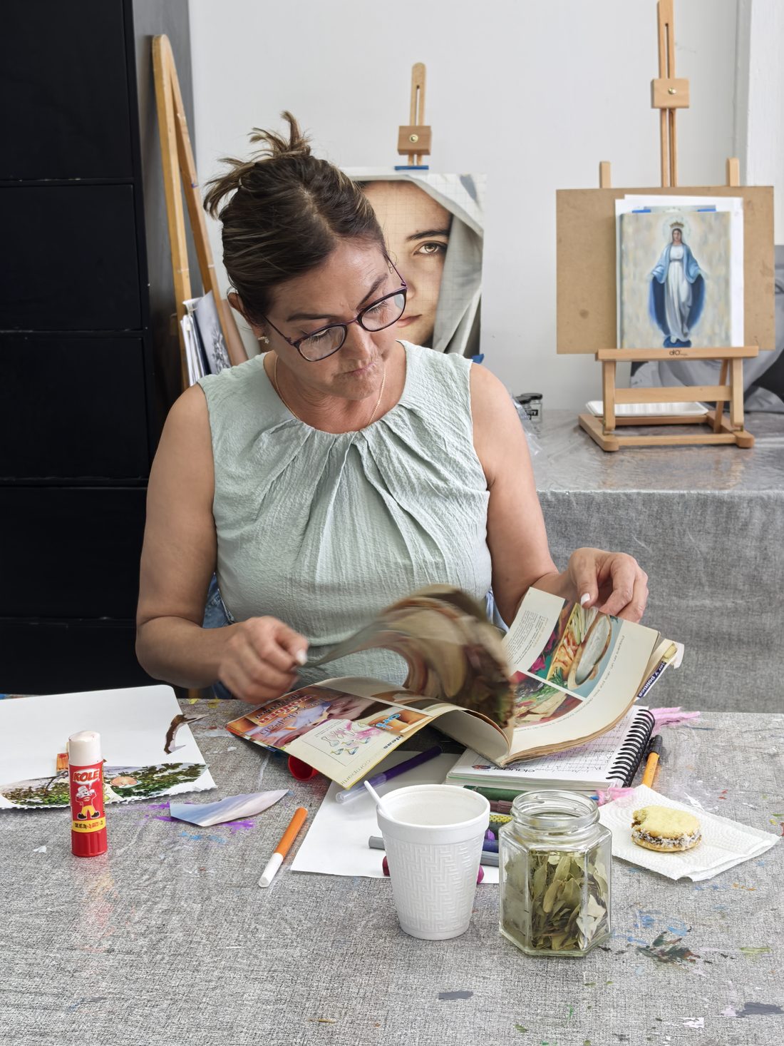 Participante explorando revistas para collage en el taller